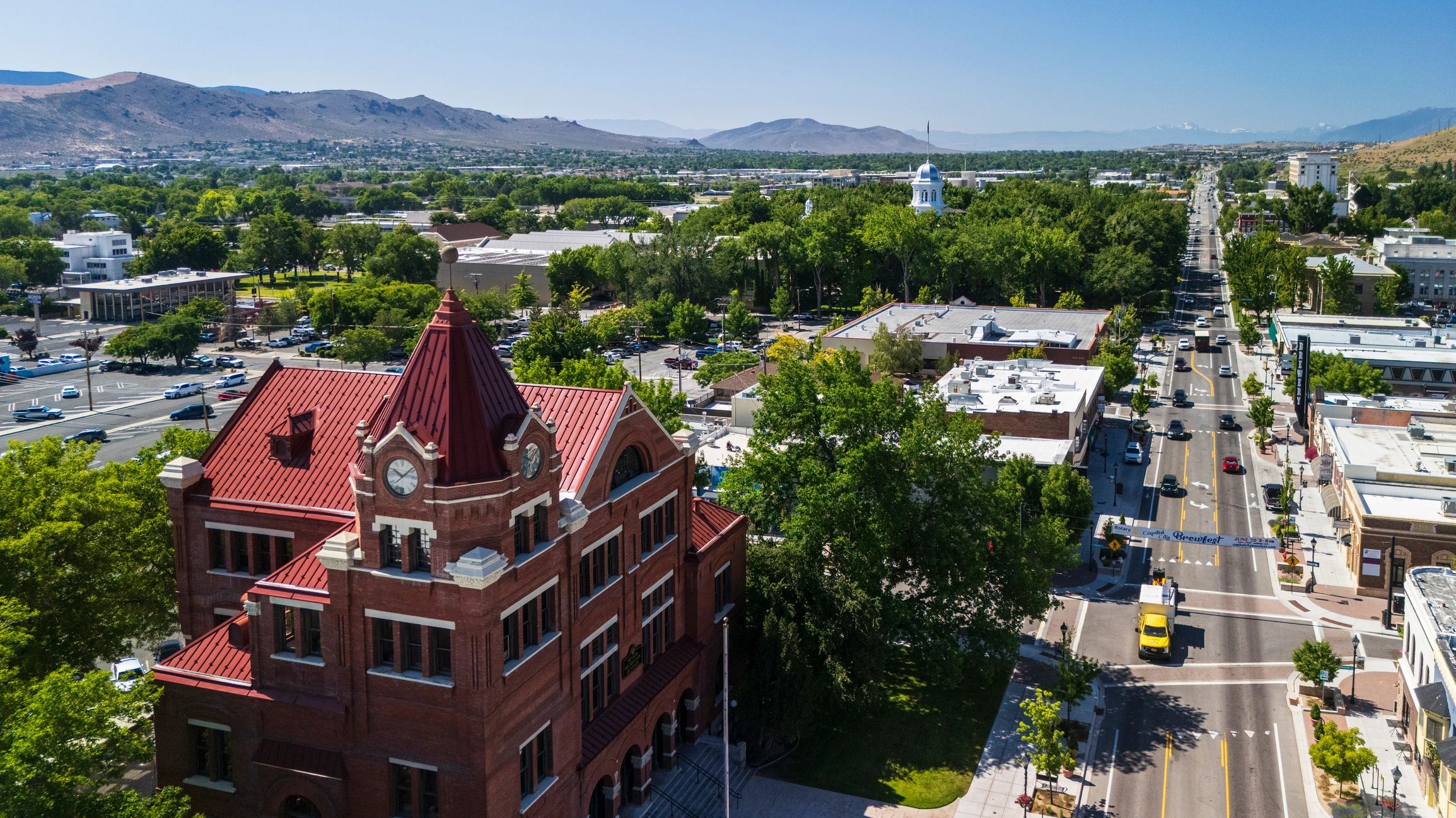 Elevated view of downtown Carson City, Nevada featuring the historic Paul Laxalt State Building and remote Nevada State Capitol under summer skies.